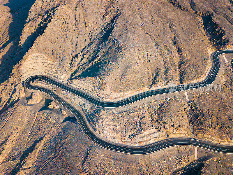 蜿蜒的沙漠道路在杰贝尔贾伊斯砂岩山在Ras Al Khaimah酋长国或阿联酋